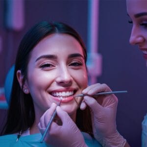 A woman getting a composite veneer by a dentist